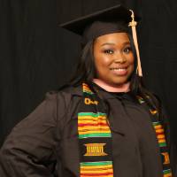 masters student posing in her cap and gown